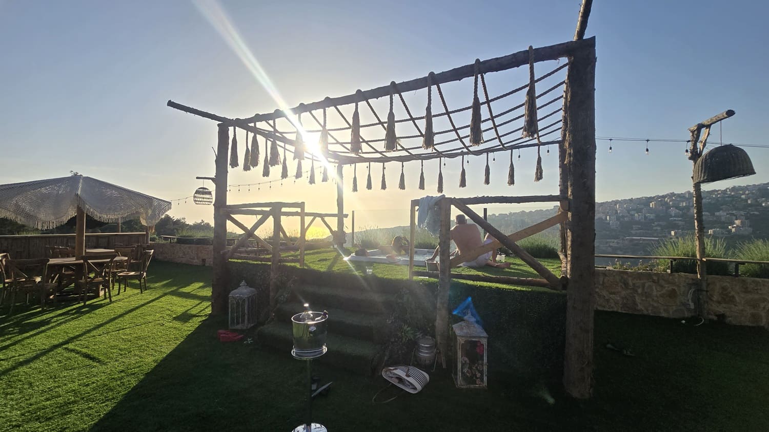 Couple relaxing in a private outdoor jacuzzi at sunset at Kaya's Resort, a luxury hotel with a scenic view near Beit Chabab, Lebanon.